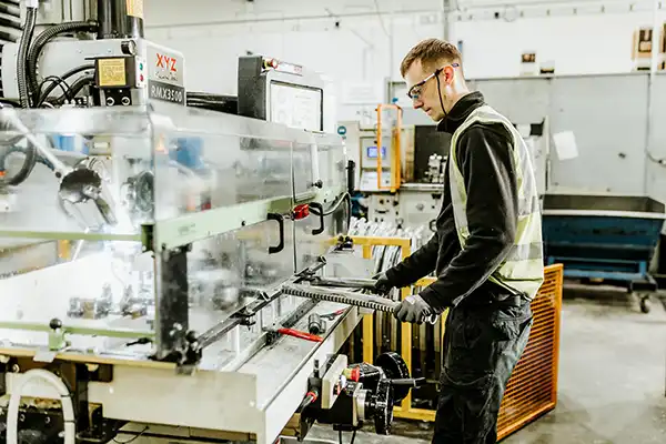 Savaria worker bending rails that are used in curved stairlifts