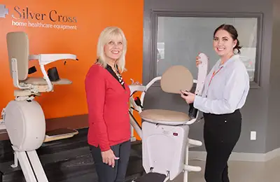 Two ladies next to stairlift demos in Silver Cross showroom