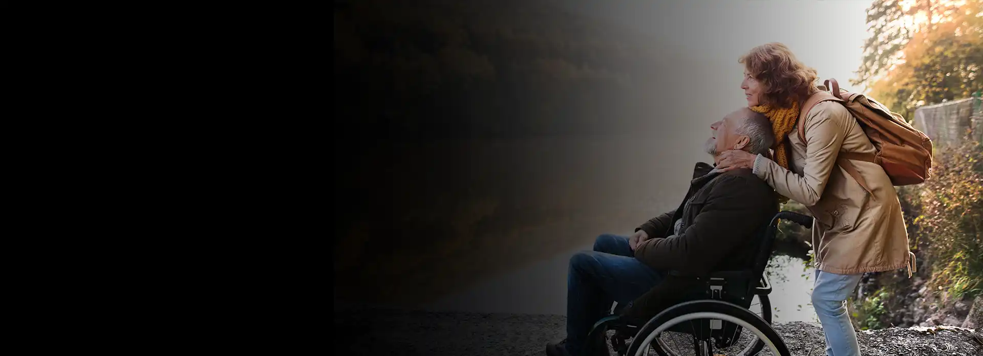 happy gentleman in wheelchair and their partner enjoying a beautiful day