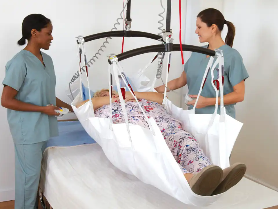 two care providers with patient in a positioning sling