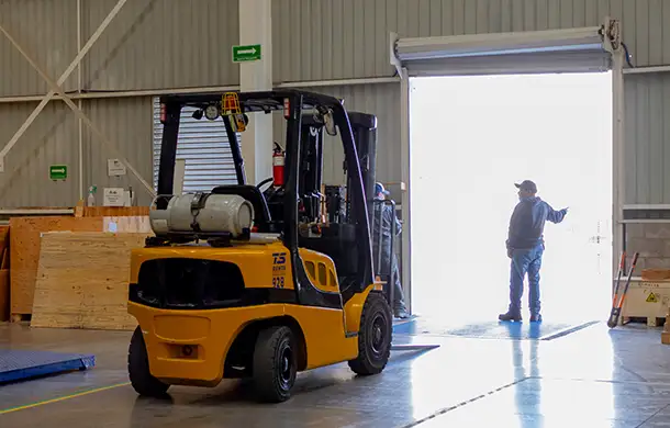 forklift near loading dock of warehouse.
