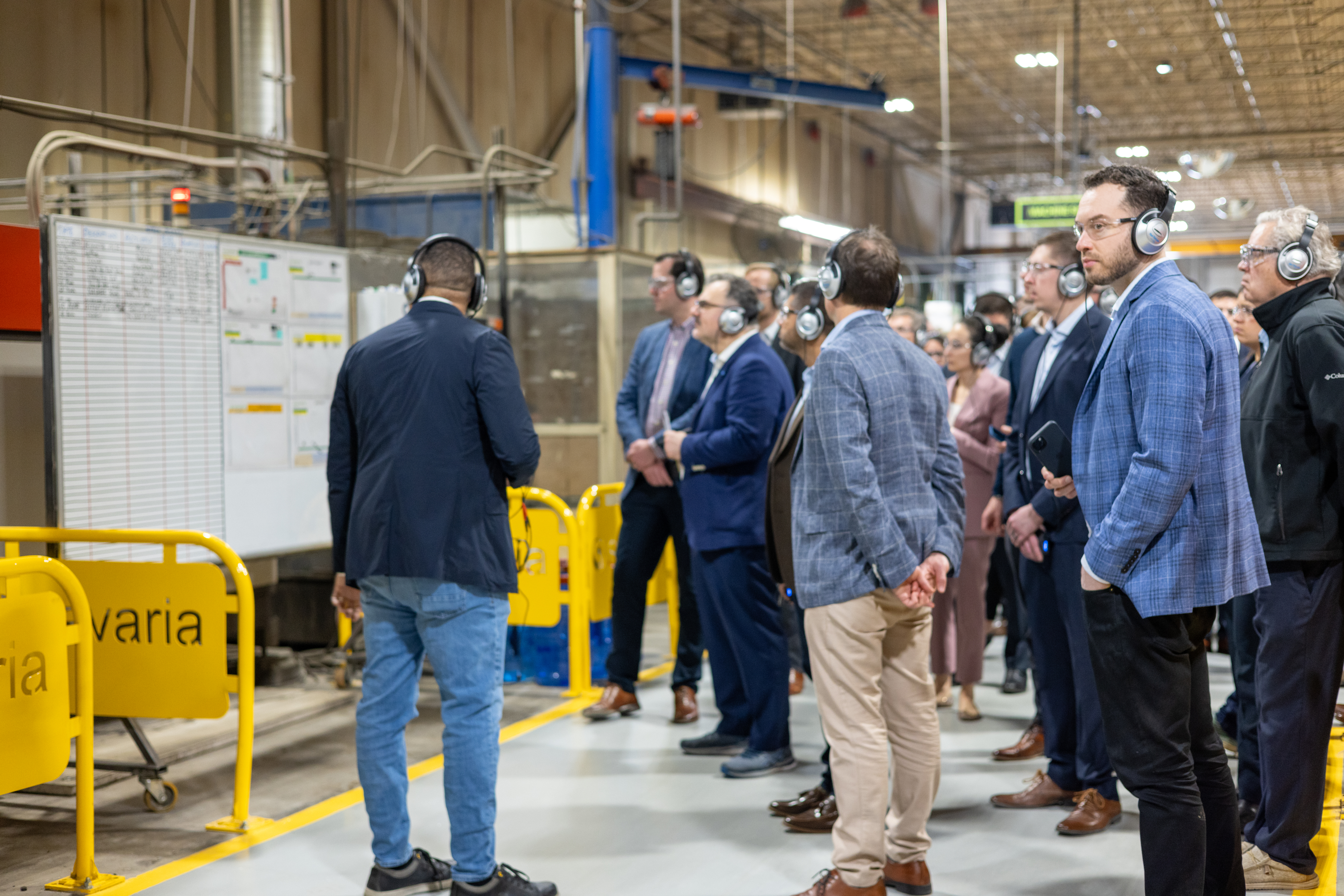 Savaria staff gathered in factory for a corporate event, wearing hearing protection