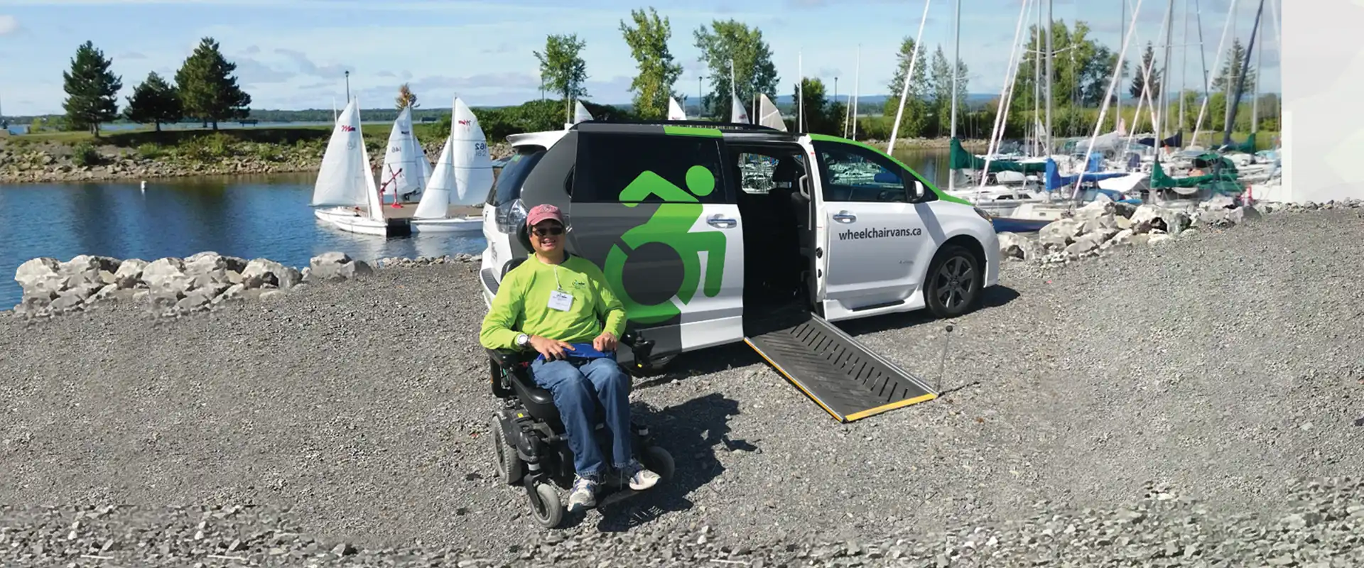 Happy person in accessibility device next to wheelchair van with open door and ramp deployed